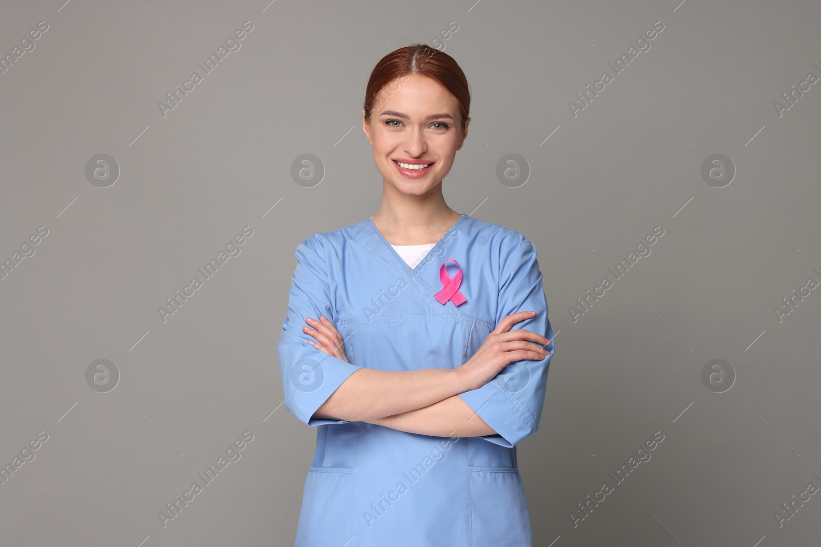 Photo of Mammologist with pink ribbon on gray background. Breast cancer awareness