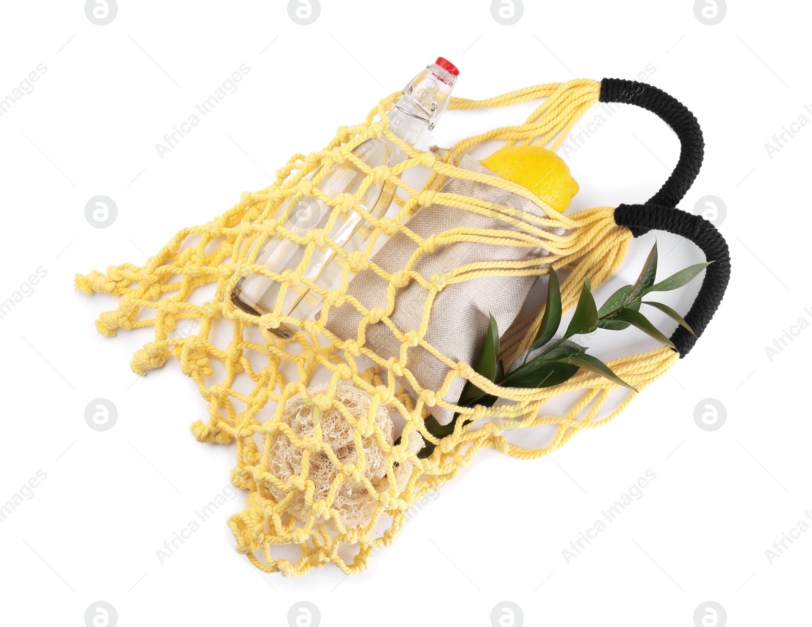 Photo of Fishnet bag with different items isolated on white, top view. Conscious consumption