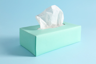 Photo of Box of paper tissues on light blue background