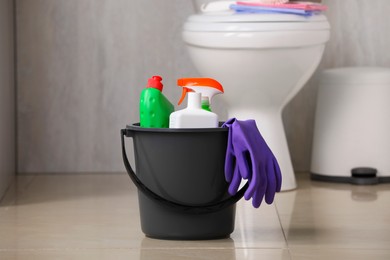 Photo of Different toilet cleaning supplies on floor indoors