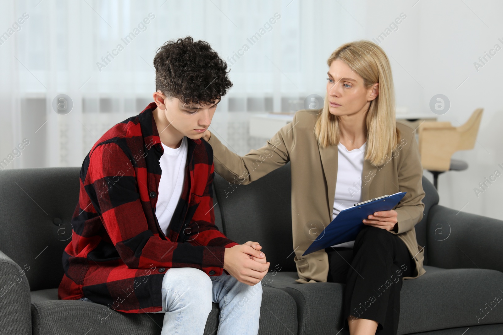 Photo of Psychologist working with teenage boy in office. Teenager problems