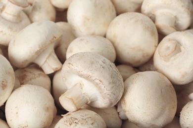 Photo of Fresh raw champignon mushrooms as background, closeup