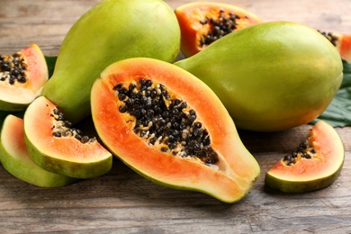 Fresh ripe papaya fruits on wooden table, closeup