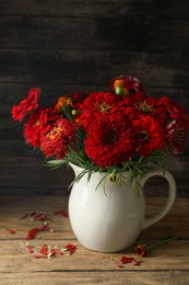 Photo of Bouquet of beautiful wild flowers on wooden table against black background