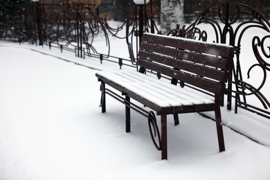 Bench covered with snow in city park