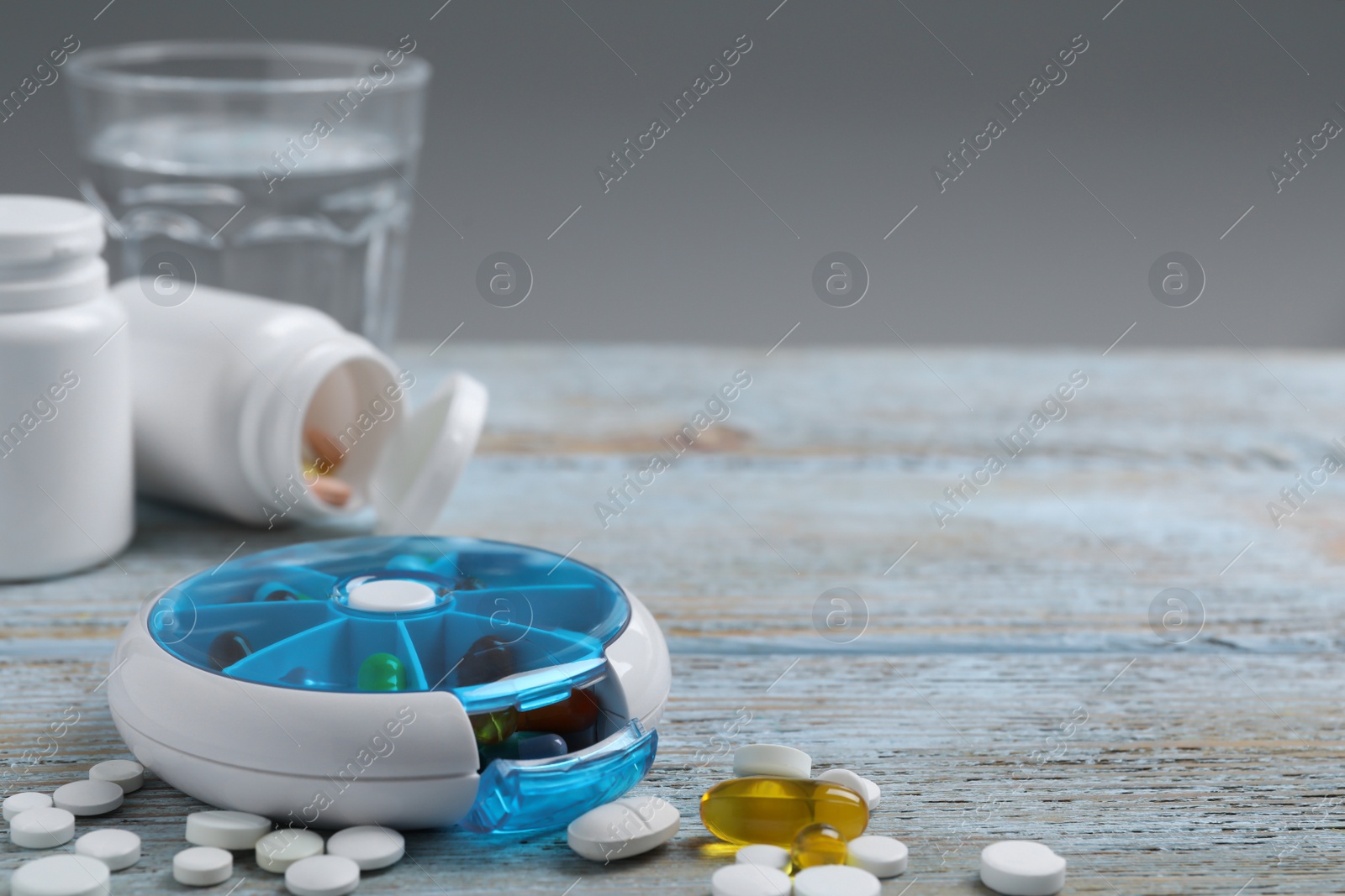 Photo of Pill box with medicaments on wooden table. Space for text