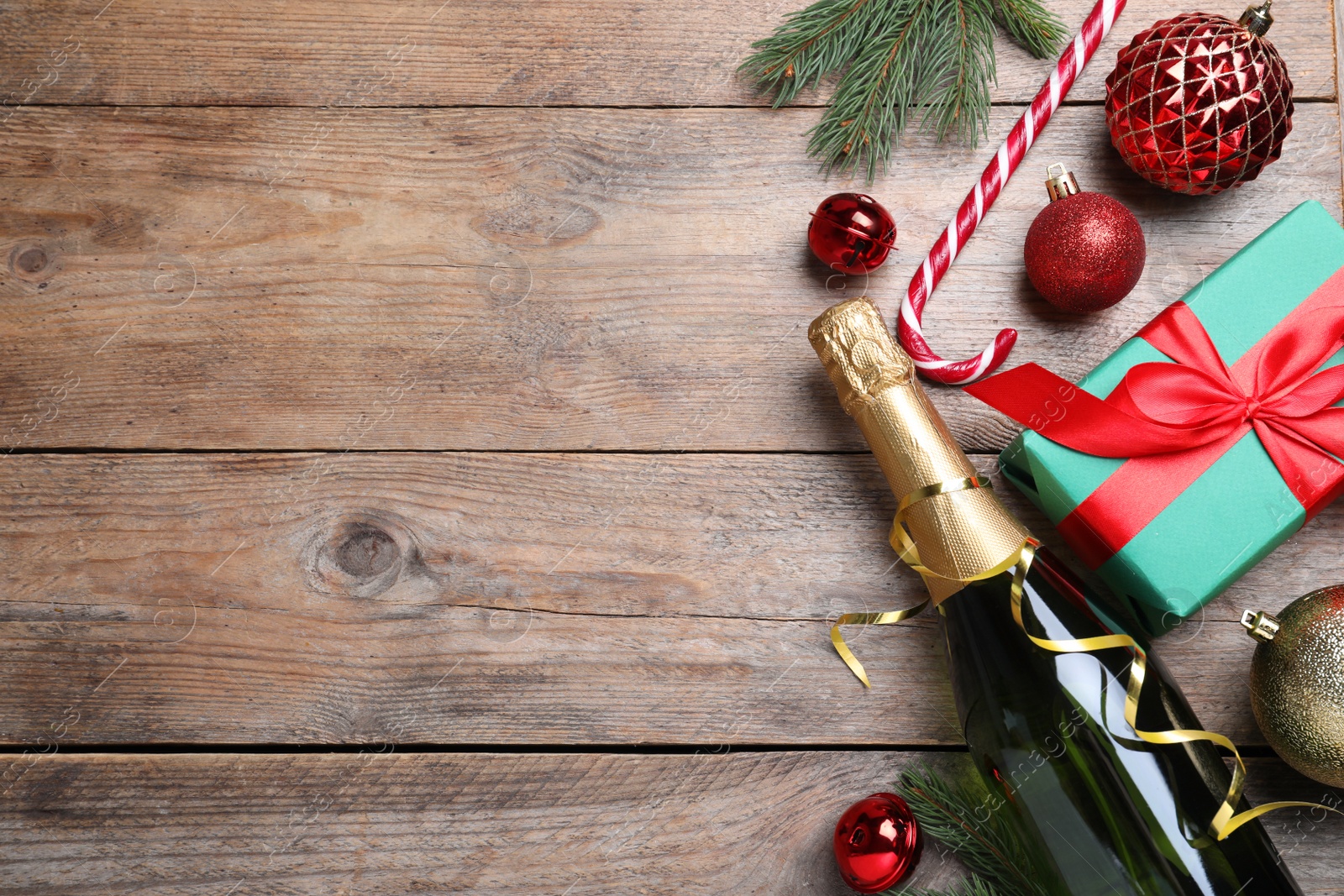 Photo of Flat lay composition with bottle of sparkling wine and festive decor on wooden background, space for text. Happy New Year