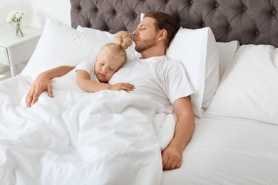 Photo of Father and his cute daughter sleeping in bed. Nap time