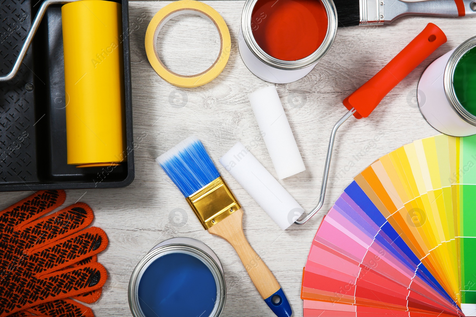 Photo of Flat lay composition with cans of paint and decorator tools on wooden background