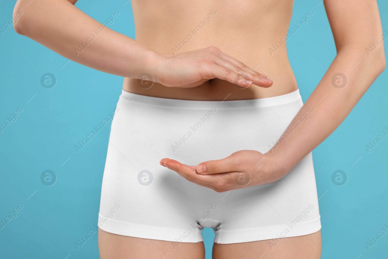 Photo of Woman holding something on light blue background, closeup. Women's health