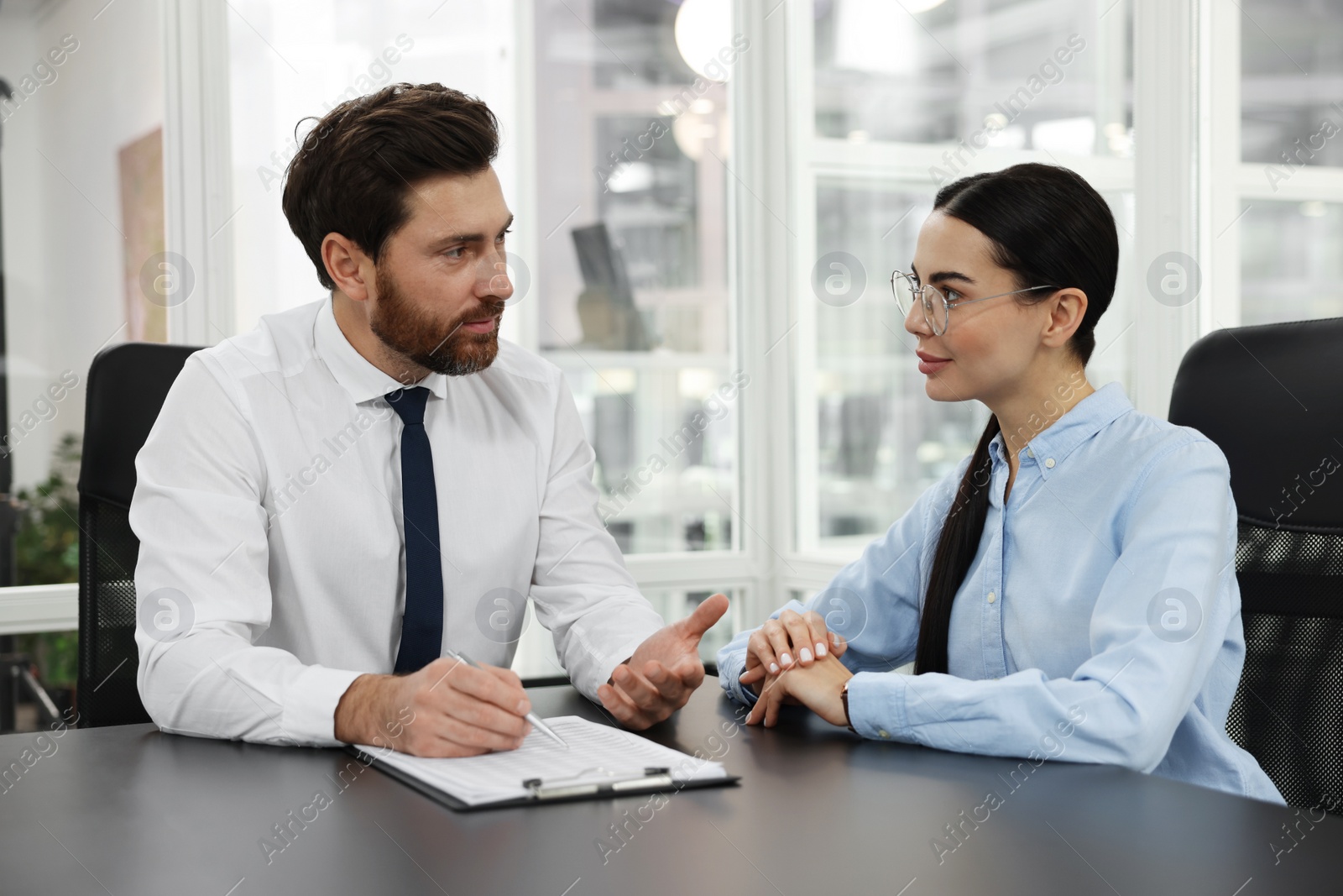 Photo of Lawyers with clipboard working together at table in office