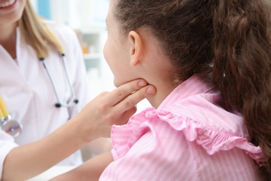 Doctor checking little girl's pulse in hospital