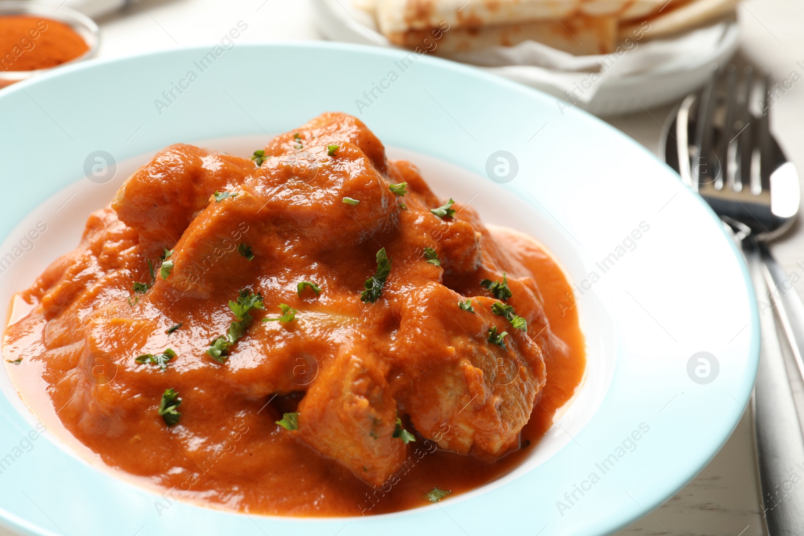 Photo of Plate of delicious butter chicken on table, closeup. Traditional Murgh Makhani dish