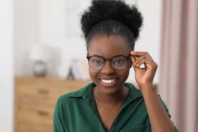Photo of Portrait of beautiful young woman in eyeglasses indoors