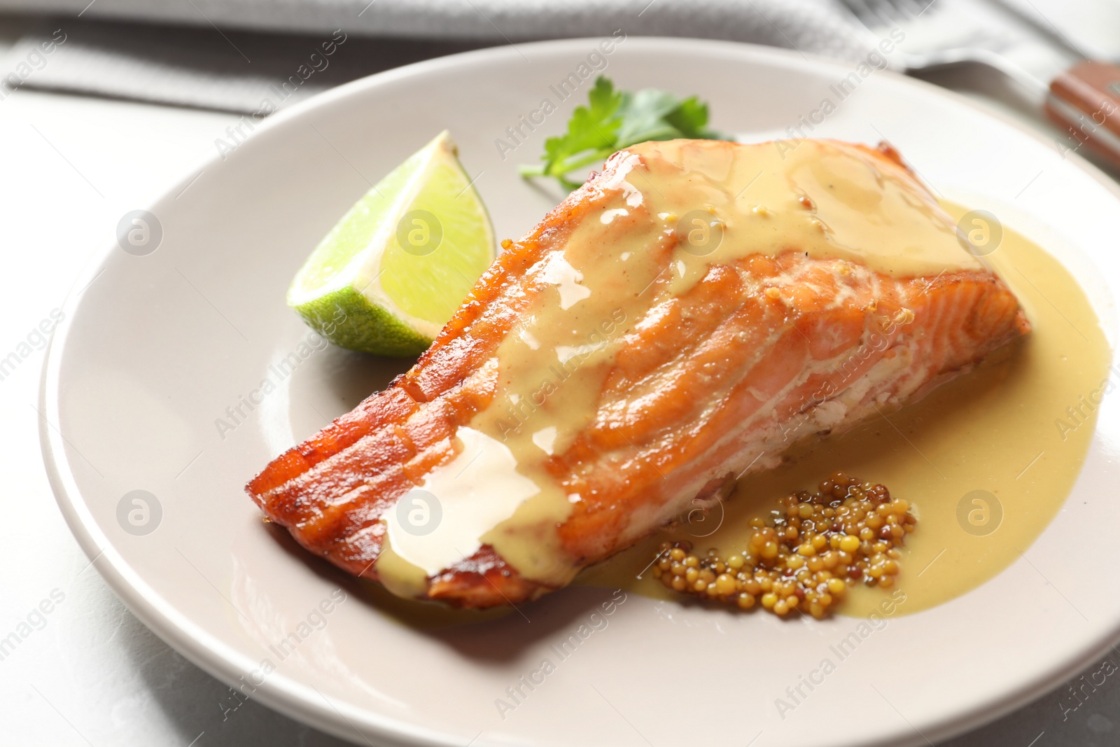 Photo of Tasty cooked salmon with mustard on plate, closeup