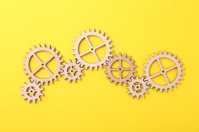 Photo of Business process organization and optimization. Scheme with wooden figures on yellow background, top view