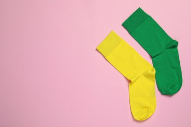 Different socks on pink background, flat lay. Space for text