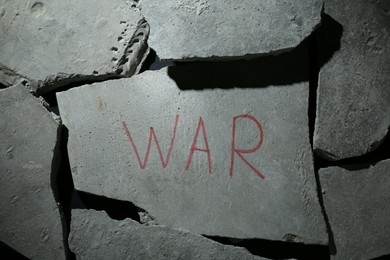 Photo of Word War written on piece of concrete, top view