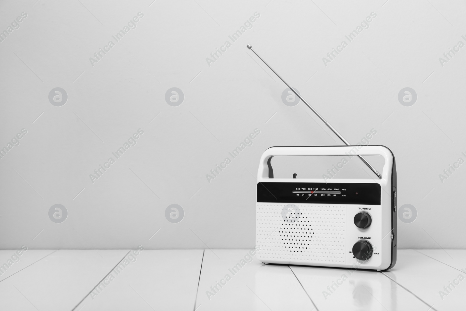 Photo of Retro radio receiver on white wooden table. Space for text