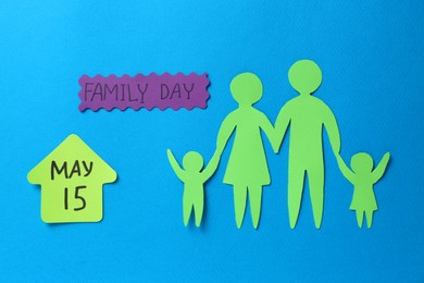 Photo of Card with text Family Day and paper cutouts on light blue background, flat lay