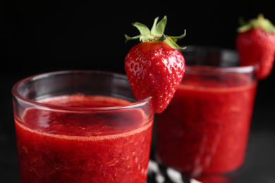 Photo of Tasty strawberry smoothie in glass on table, closeup