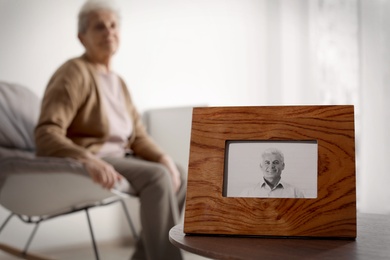 Framed photo of man and blurred female pensioner on background. Space for text