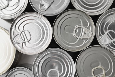 Photo of Many closed tin cans as background, top view