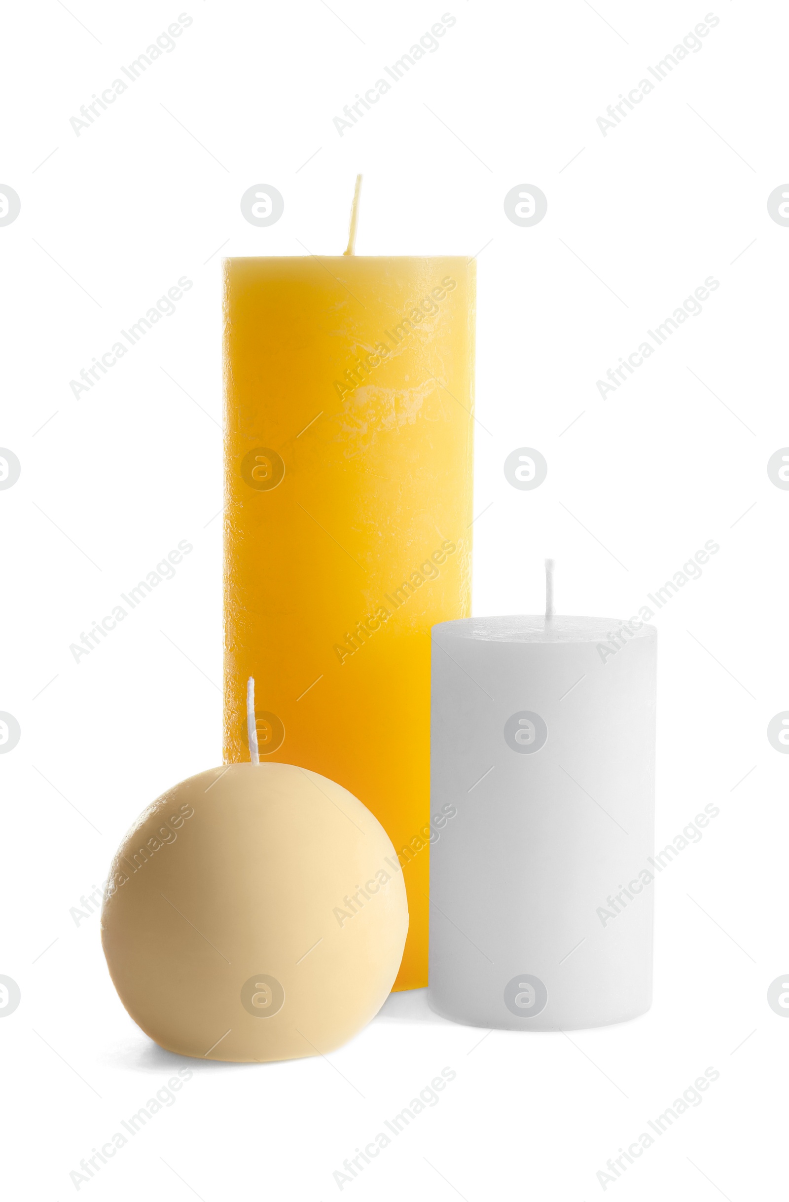 Photo of New wax candles of different shapes on white background