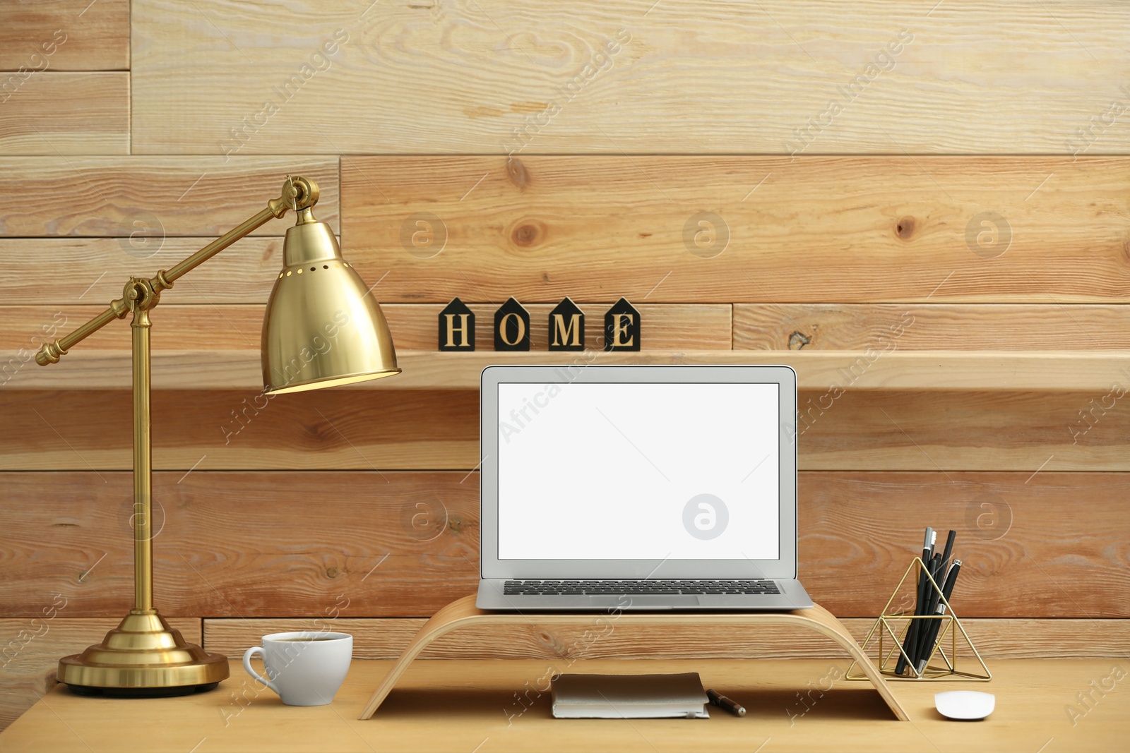 Photo of Modern laptop on desk in room. Home workplace