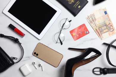 Flat lay composition with passport, money and accessories on white marble background. Packing for business trip