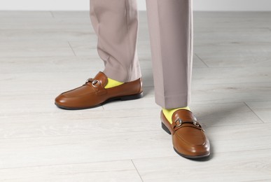 Man wearing stylish shoes and yellow socks indoors, closeup