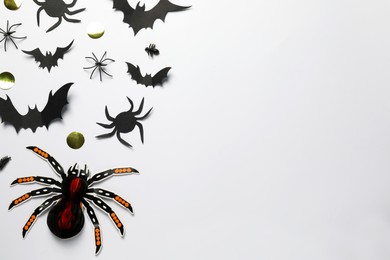 Photo of Flat lay composition with paper bats and spiders on white background, space for text. Halloween celebration