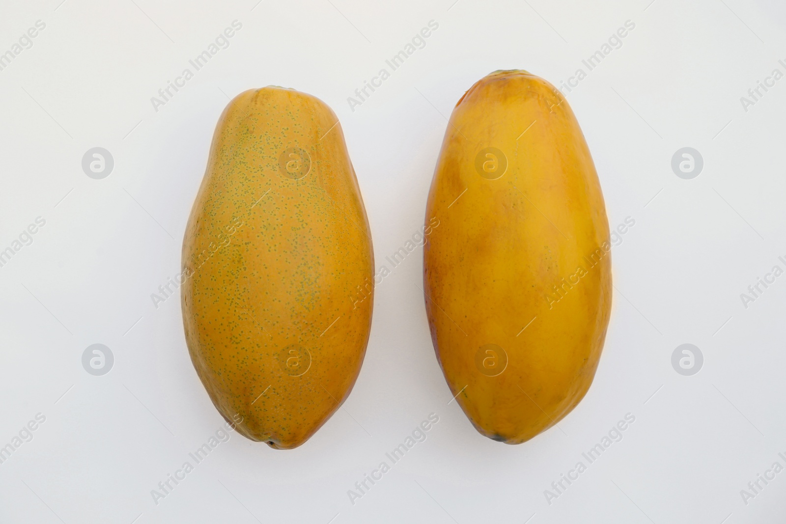 Photo of Fresh ripe papaya fruits on white background, flat lay