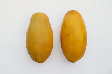 Photo of Fresh ripe papaya fruits on white background, flat lay