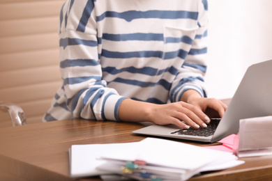 Young journalist working with laptop in office, closeup