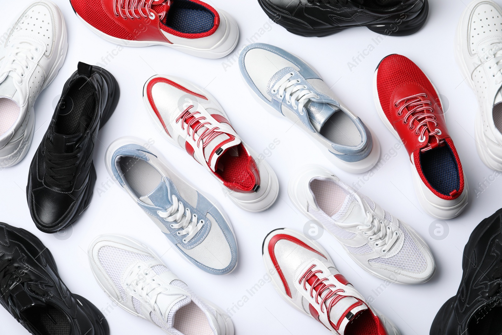 Photo of Many stylish sneakers on white background, top view