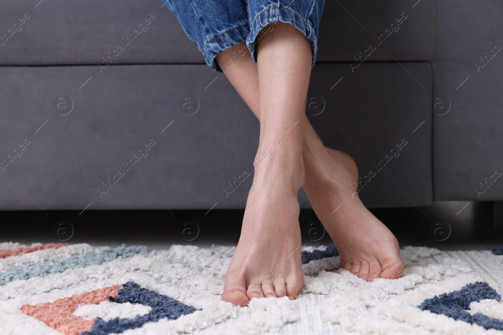 Photo of Woman on carpet with pattern at home, closeup