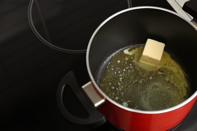 Pot with melted butter on stove. Space for text