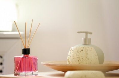 Aromatic reed air freshener and toiletries on table indoors