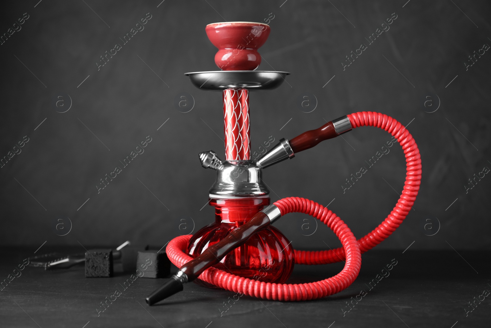 Photo of Red traditional hookah on black slate table