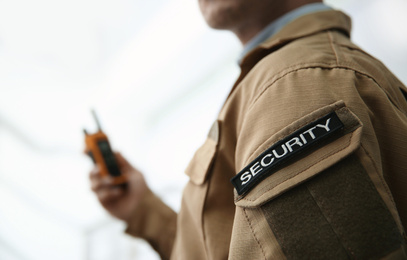 Photo of Chevron with word SECURITY on guard's uniform on light background, closeup