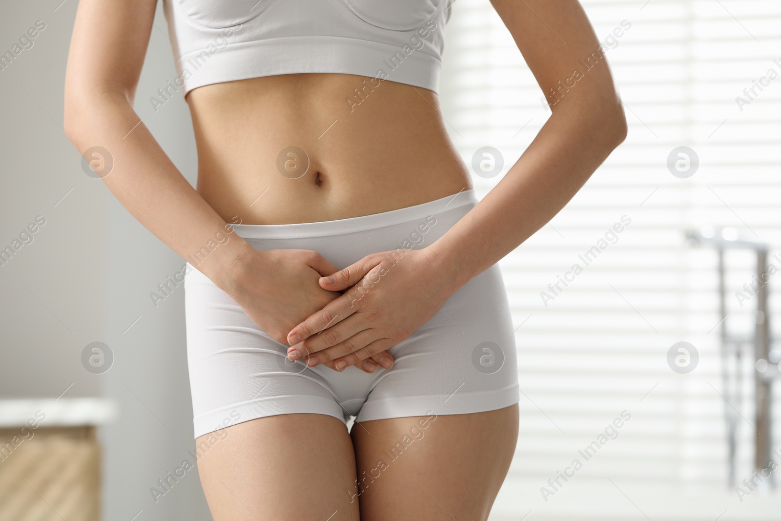 Photo of Woman suffering from cystitis at home, closeup