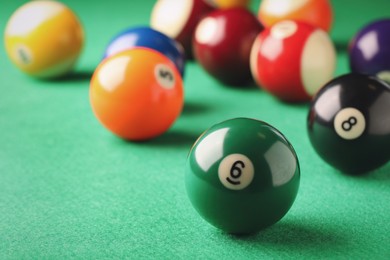 Photo of Billiard ball with number 6 on green table, closeup. Space for text