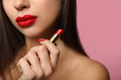 Photo of Woman with red lipstick on pink background, closeup