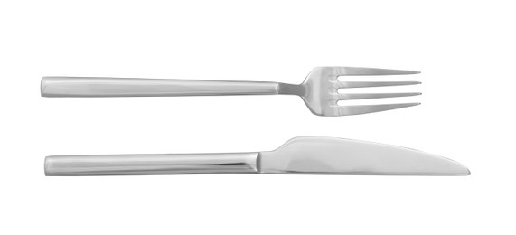 Photo of Knife and fork isolated on white, top view. Stylish shiny cutlery set
