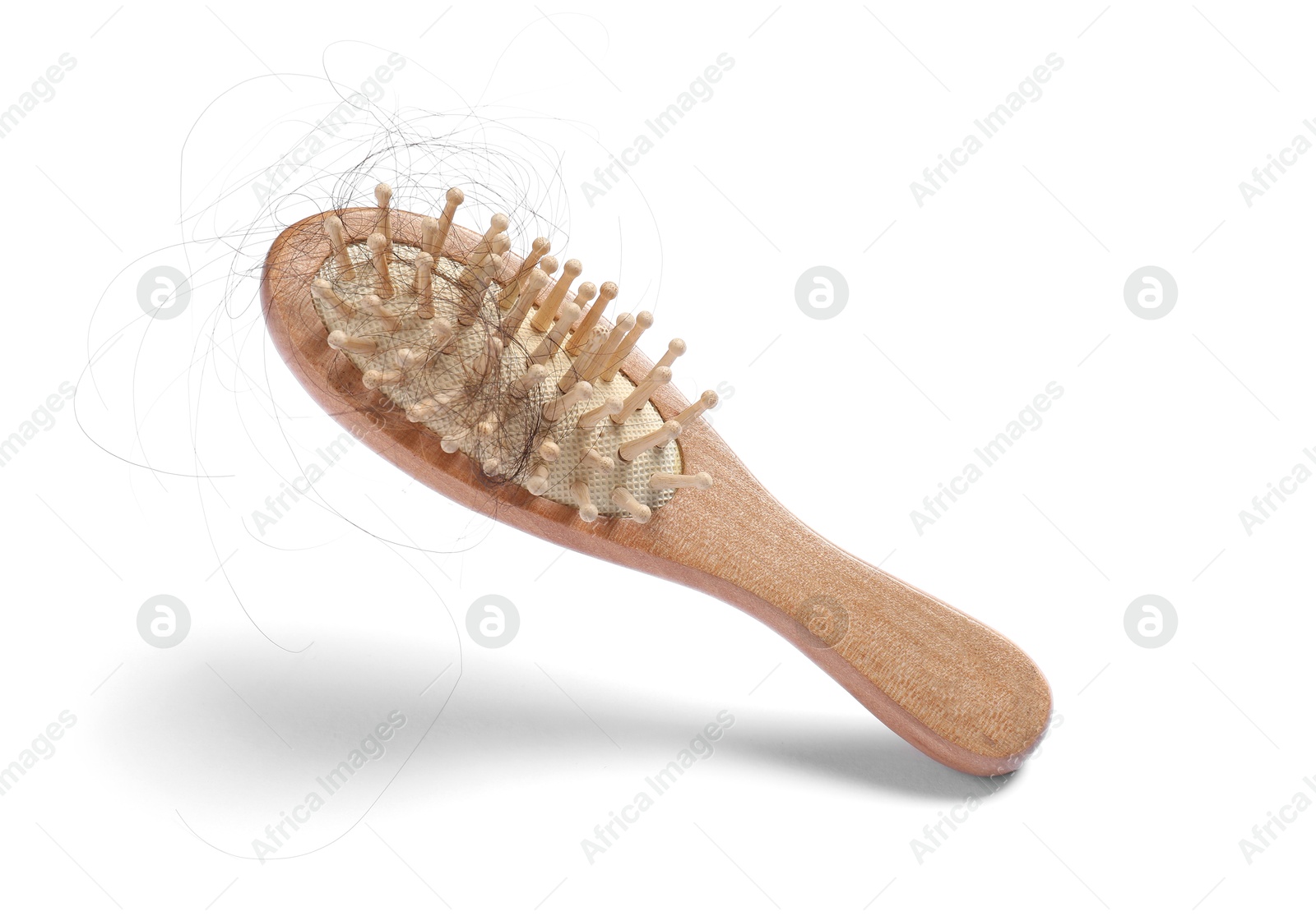 Photo of Brush with lost hair in air on white background