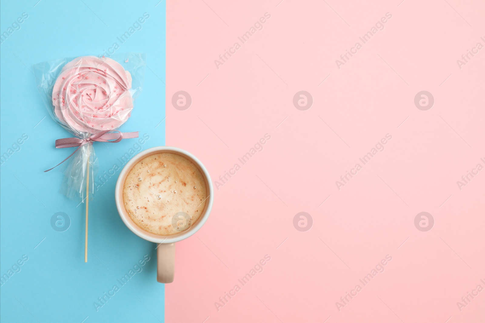 Photo of Cup of coffee and candy on color background, top view. Space for text