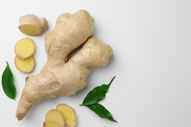 Photo of Fresh ginger with green leaves on white background, flat lay. Space for text