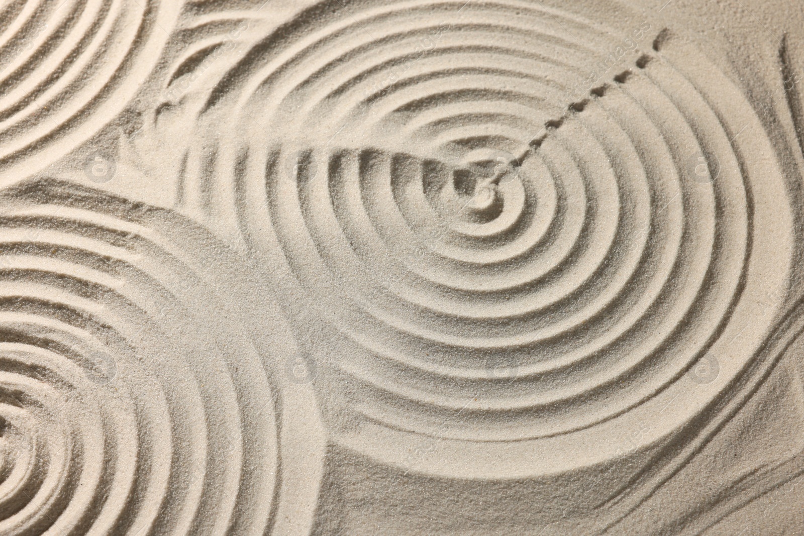 Photo of Beautiful spirals on sand, closeup. Zen garden