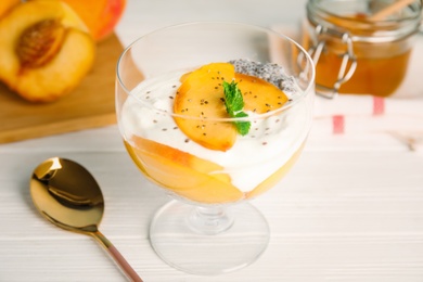 Tasty peach dessert with yogurt and chia seeds served on white wooden table